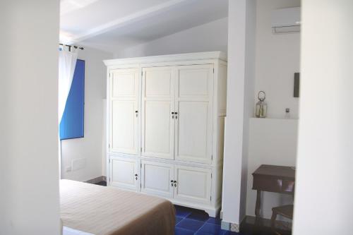 a bedroom with a white cabinet and a bed at Avocado B&B Beyond in Giardini Naxos