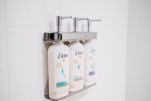 a row of four bottles of detergent on a shelf at Holiday Inn Express & Suites Raleigh Durham Airport at RTP by IHG in Durham