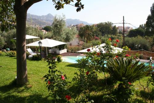 a garden with a swimming pool and some flowers at Avocado B&B Beyond in Giardini Naxos