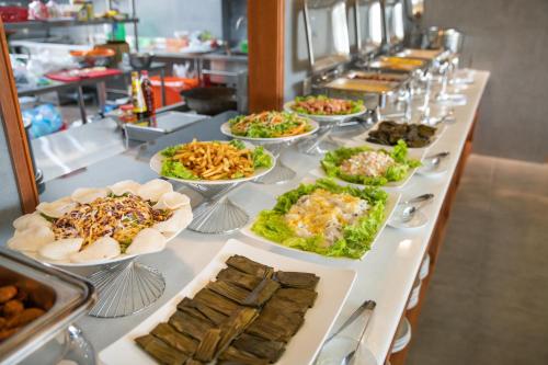 Yes Hotel Đà Nẵng في دا نانغ: طابور بوفيه مع اطباق طعام على طاولة