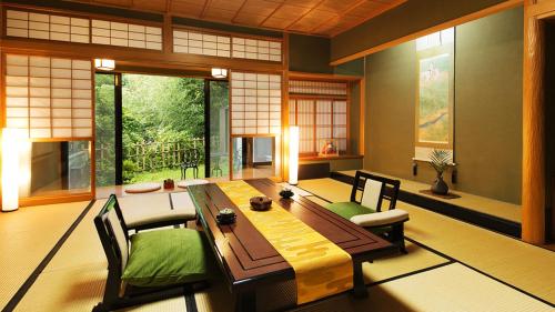 a dining room with a wooden table and chairs at Kocho in Kaga