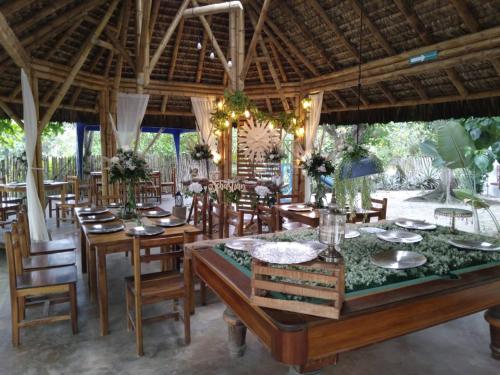 una sala da pranzo con tavoli e sedie in legno di Hotel Bambú a Canoa