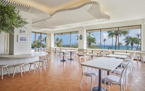 restauracja ze stołami i krzesłami oraz widokiem na ocean w obiekcie Caesar Park Hotel Kenting w Kenting
