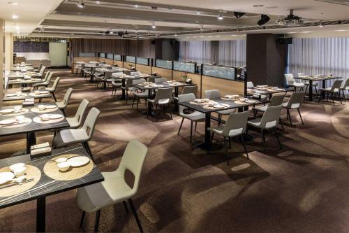 een grote eetkamer met tafels en stoelen bij Hsin Hotel in Chiayi City