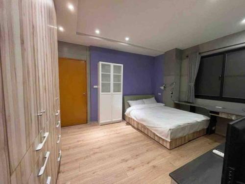 a bedroom with a bed and a flat screen tv at FengJia Pleasure Life 2 in Taichung