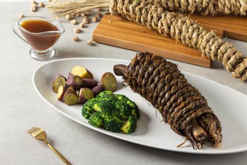 a plate of food with meat and vegetables on a table at Hsin Hotel in Chiayi City