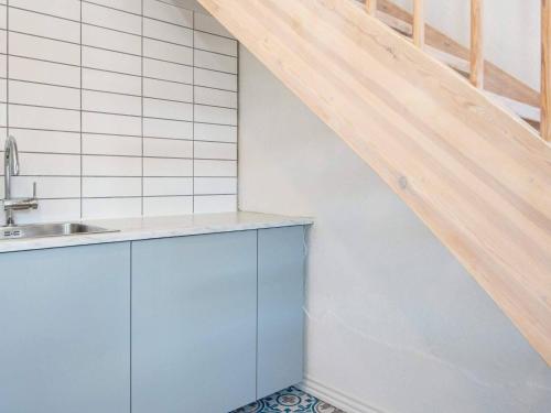 a kitchen with blue cabinets and a wooden staircase at 12 person holiday home in Sønder Omme-By Traum in Sønder Omme