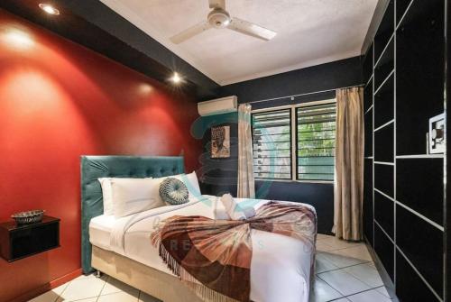 - une chambre avec des murs rouges et noirs et un lit dans l'établissement ZEN MARKETS - Boutique 1-BR Apt Near Parap Markets, à Paraparap