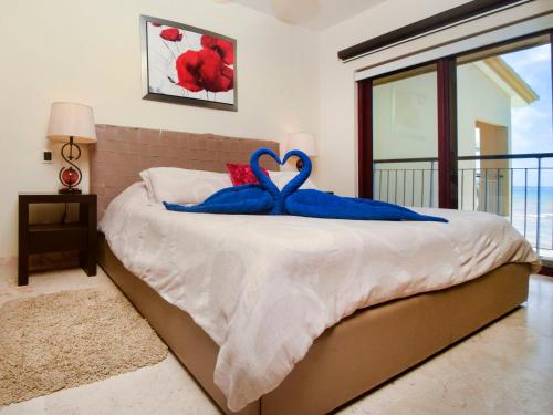 Un dormitorio con una cama con almohadas azules. en Spacious beachfront condo True Oceanfront 1bdrm 2bath Surf 308, en Playa del Carmen