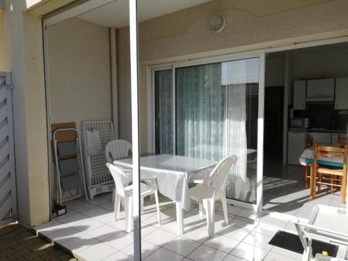 Elle comprend un balcon doté d'une table et de chaises blanches. dans l'établissement Studio Cabine à Biscarrosse Plage - 4 Pers, Proche Plage et Commerces, Terrasse, Ménage Inclus - FR-1-319-394, à Biscarrosse-Plage