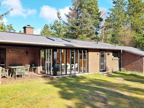 a brick house with a table and chairs in a yard at 6 person holiday home in N rre Nebel in Lønne Hede