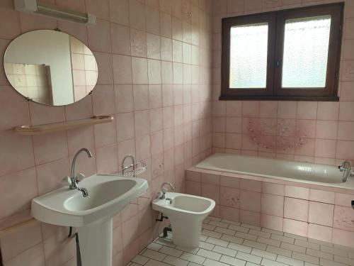 un bagno con un lavandino, una vasca e uno specchio di Maison Calme avec Jardin, Proche Lac et Centre, Animaux Bienvenus, Ménage Inclus - FR-1-319-408 a Sanguinet