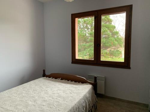 una camera da letto con un letto e una finestra di Maison Calme avec Jardin, Proche Lac et Centre, Animaux Bienvenus, Ménage Inclus - FR-1-319-408 a Sanguinet