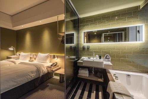 a hotel room with a bed and a bath tub at Ramble Hotel in Taichung