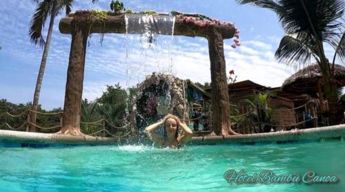 una mujer en el agua en una piscina en Hotel Bambú, en Canoa