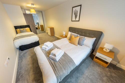 a bedroom with a bed with towels on it at Lovely 4-sleeper Apartment in Central Slough with Free Parking in Slough