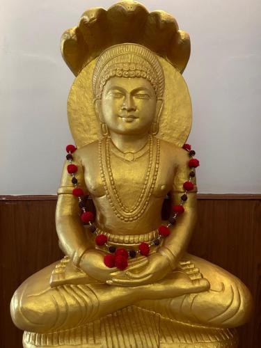 una estatua de oro de un buddha con cuentas rojas en Ganga Vatika Boutique Hotel, Rishikesh en Rishīkesh