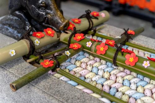 a group of bamboo sticks with flowers on them at RESI STAY Jisco Hotel Kyoto Goshonishi in Kyoto