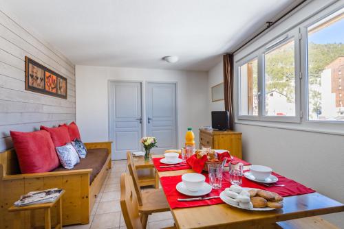 - une salle à manger avec une table et un canapé dans l'établissement Lagrange Vacances L'Orée des Cîmes, aux Angles