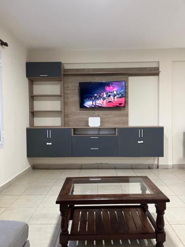 ein Wohnzimmer mit einem TV und einem Couchtisch in der Unterkunft Departamento con excelente ubicación in Yerba Buena