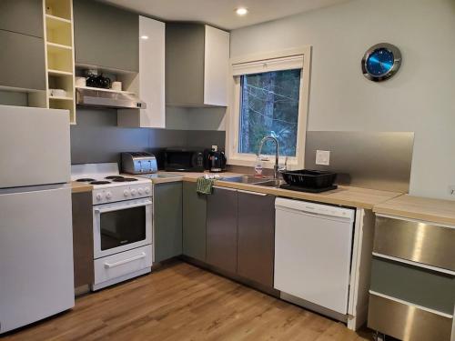 a kitchen with a sink and a stove top oven at Saratoga beach cottage, private non-resort, easy beach access, 35mins Mt Washington in Oyster Bay