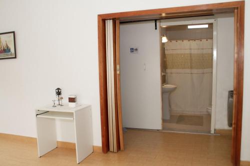 a bathroom with a toilet and a sliding glass door at Guanaco Hostel in Puerto Madryn