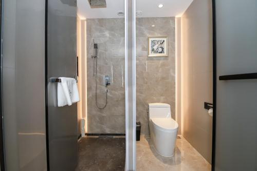a bathroom with a shower and a toilet in it at Qianhe International Hotel in Jiuzhaigou