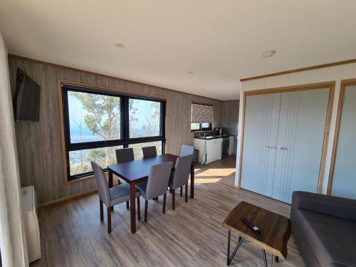 a dining room with a table and chairs and a kitchen at Mount Rumney Escapes Seaview House 2 - Eagle House in Mount Rumney