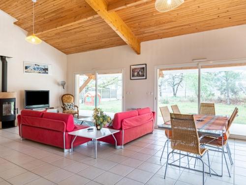 un salon avec des canapés rouges et une table dans l'établissement Grande maison familiale 4 chambres, 140m², proche forêt, terrasse et jardin clos, Biscarrosse - FR-1-521-22, à Biscarrosse