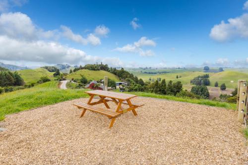 a wooden picnic table sitting on top of a hill at Nadarra Hideaway in Otorohanga