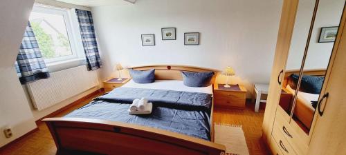 a bedroom with a bed with blue sheets and blue pillows at FeWo-1-OG-links in St. Peter-Ording