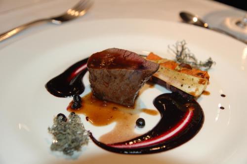 a white plate with chocolate dessert on a table at Demians in Saldus