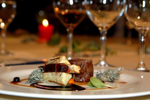 a plate of food on a table with wine glasses at Demians in Saldus