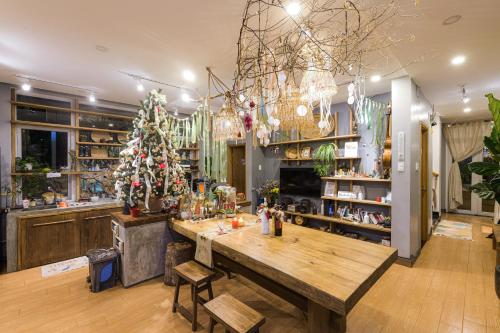 a room with a wooden table and a christmas tree at Dahlia Dalat in Xuan An