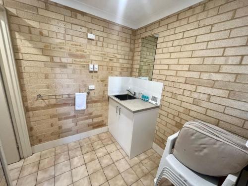 a bathroom with a sink and a chair in it at Family Getaway Cabin 50 in Broadwater