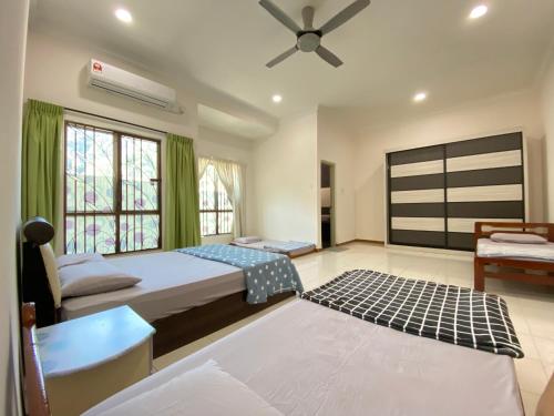 a bedroom with two beds and a ceiling fan at Taman Saikat IPOH comfortable HomeStay 12 Pax in Ipoh