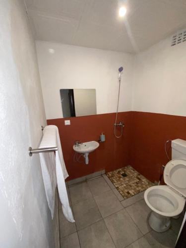 a bathroom with a toilet and a sink at Aeropark Residencial (B&B) in Maputo
