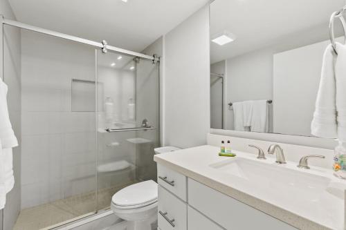 a white bathroom with a sink and a toilet at New Stunning Ocean-View Condo in Beachfront Resort in South Padre Island