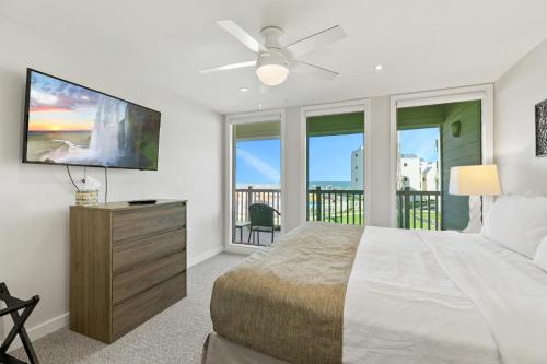 a bedroom with a large bed and a flat screen tv at New Stunning Ocean-View Condo in Beachfront Resort in South Padre Island