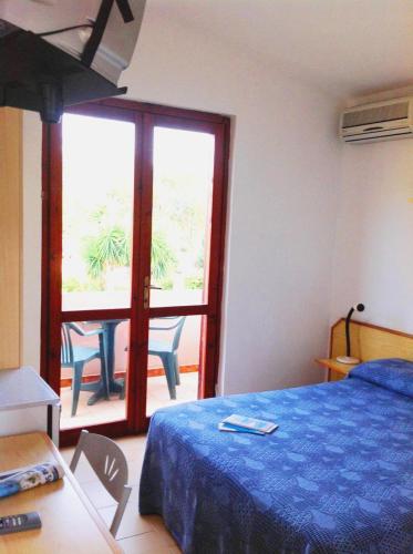 a bedroom with a bed and a sliding glass door at Verdemare Sardegna Due Villette in Villasimius