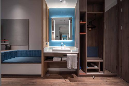a bathroom with a sink and a mirror at Holiday Inn Express Zhengzhou Guancheng, an IHG Hotel in Zhengzhou