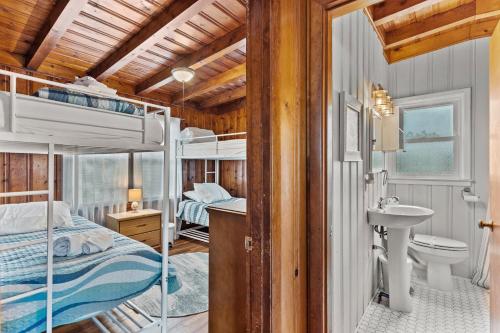 a bedroom with bunk beds and a bathroom with a sink at Dock Holiday in Oak Island