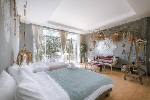 a large bedroom with two beds and a chair at Dahlia Dalat in Xuan An