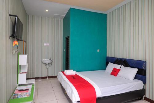 a bedroom with a large bed with a green wall at RedDoorz Syariah near Gardu Pandang Dieng in Kejajar