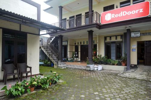 a building with a sign on the side of it at RedDoorz Syariah near Gardu Pandang Dieng in Kejajar