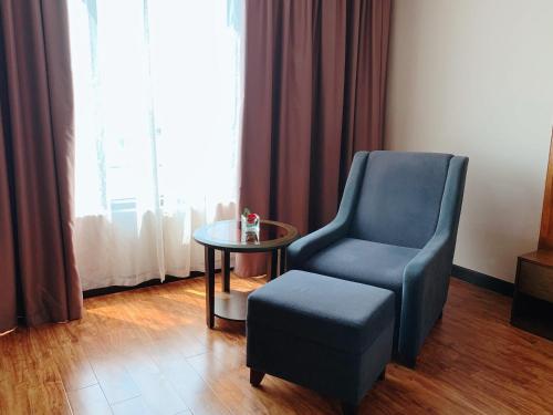 a living room with a chair and a table at Muong Thanh Luxury Nhat Le Hotel in Dong Hoi