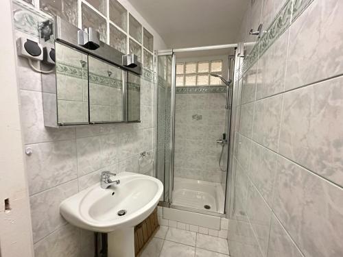 La salle de bains blanche est pourvue d'un lavabo et d'une douche. dans l'établissement Maison Collioure, 3 pièces, 4 personnes - FR-1-309-368, à Collioure