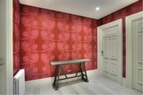 a room with a bench and red wall at The Inn on the Mile in Edinburgh