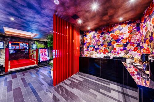 a restaurant with red doors and a colorful wall at Hotel Lotus Umeda -Adult Only in Osaka
