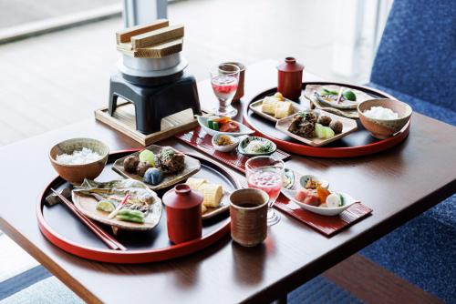una mesa con tres platos de comida en una mesa en Biwako Hotel, en Otsu